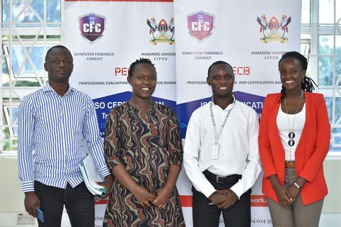 Four participants in front of CFC and PECB banners